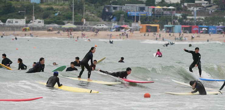 송정 바다에서 서핑을 즐기는 서퍼들 모습.
