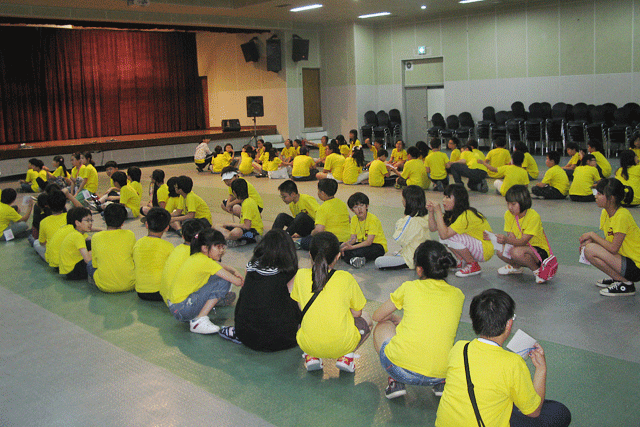 대강당 실내에 아이들이 앉아있는 사진