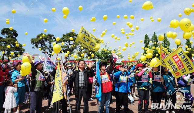 김해공항 가덕이전 염원 부산시민 걷기대회에서 참가자들이 노란 소망풍선을 하늘로 날리는 모습