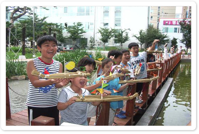 여름방학 체험교육 프로그램인 띠 배 만들기 참가 어린이들이 자신이 직접만든 띠배를 들고 즐거워 하는 모습